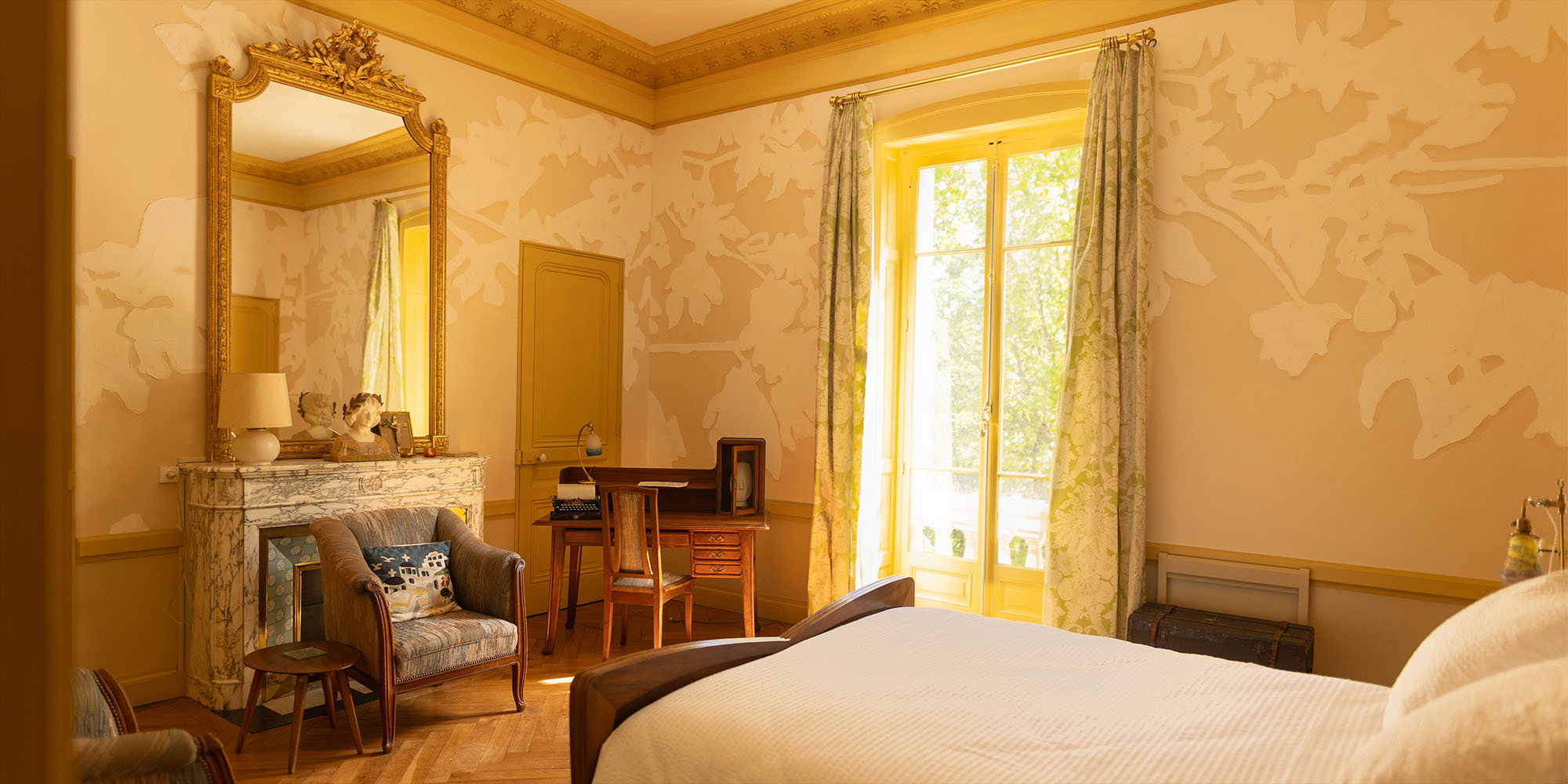 Overview of the room with its Art Nouveau furniture and the soft light from the large window.
